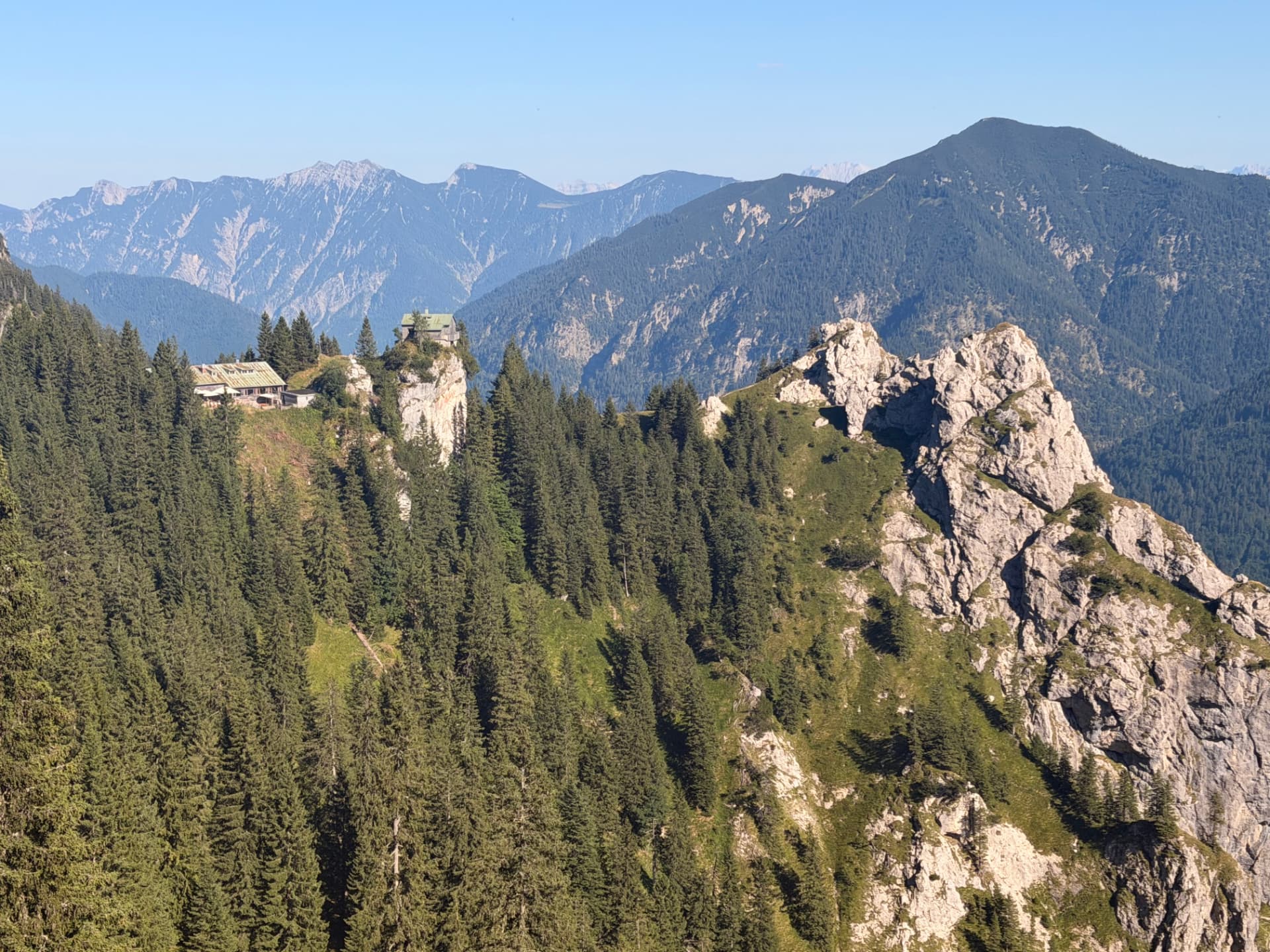 A traditional mountain hut perched on a rocky ridge in the Bavarian Alps