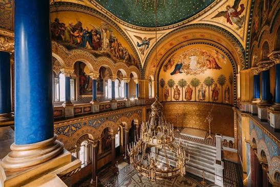 Ornate hall inside Neuschwanstein Castle with painted arches and chandelier